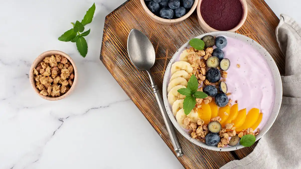 Jogurt z granolą i owocami jako przykład posiłku zbilansowanej diety.
